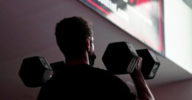 man in black t-shirt holding black dumbbell